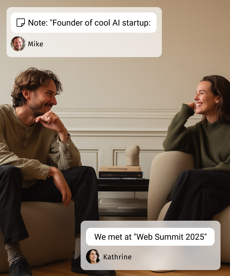 A man and woman sitting on beige chairs facing each other, smiling and having a conversation in a cozy room.